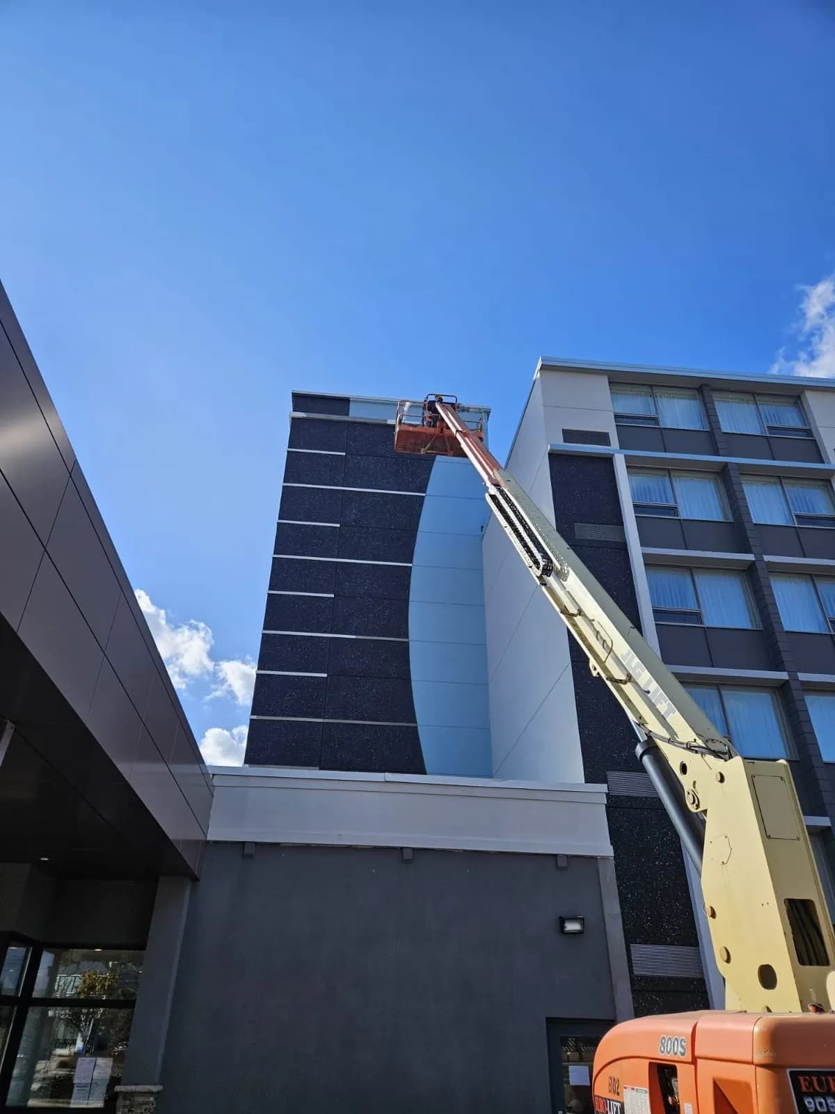 Holiday Inn, Burlington — Boom lift at the parapet, working the top of the curve