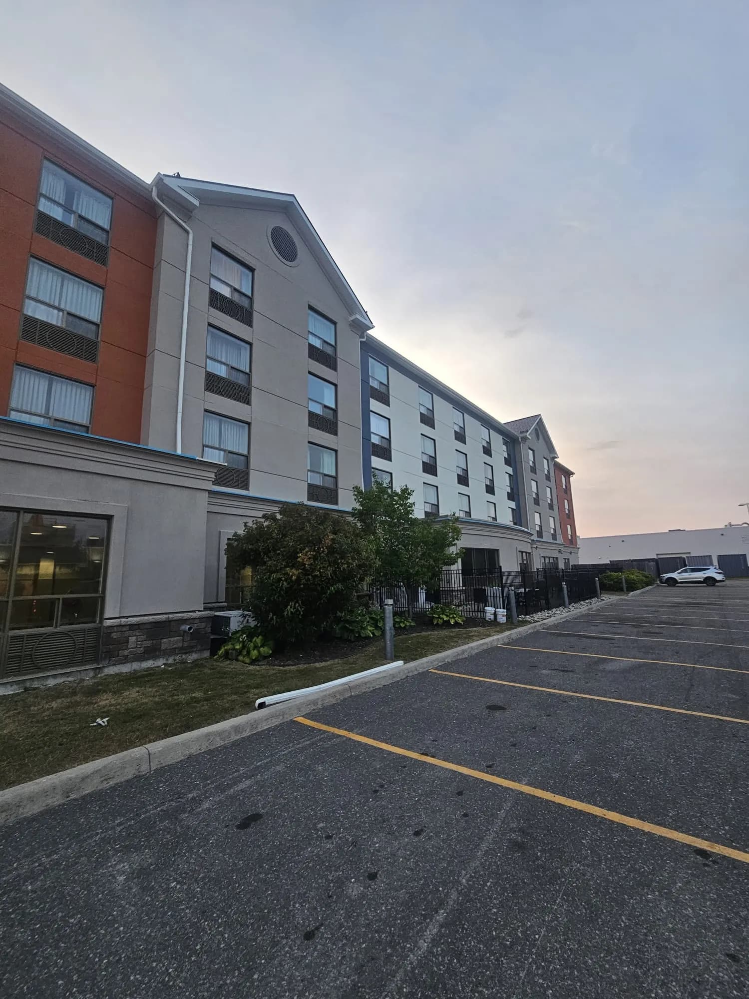 Holiday Inn Express, New Liskeard — The long elevation from the lot, colour breaks landing on the returns