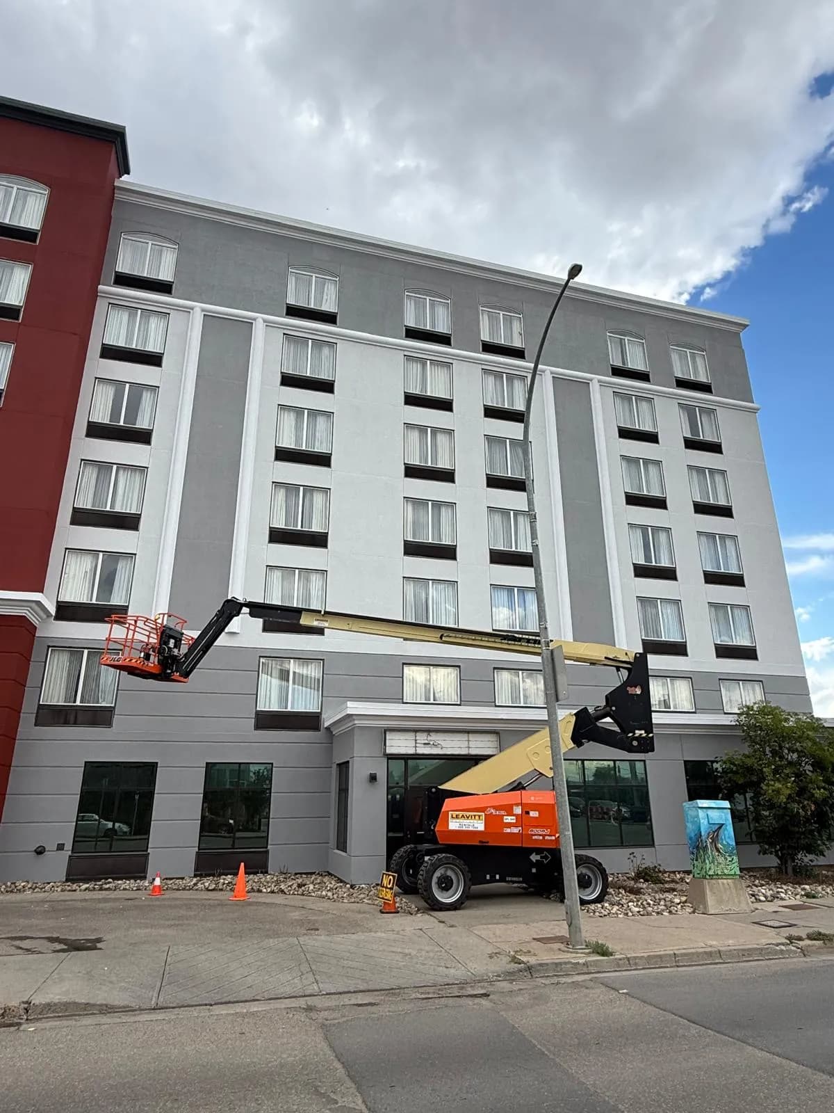 Wingate by Wyndham, Regina — Grey guest room wing, boom lift at the second floor band